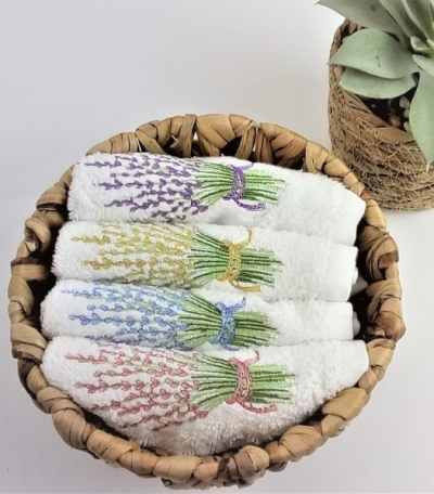 Small face towels lavender embroidery for guest bathroom in a woven basket.