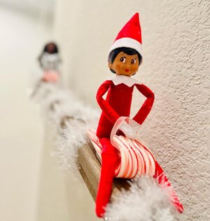 Sledding-down-the-staircase-railing-Elf-on-the-Shelf-idea